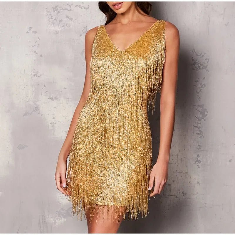 Gold fringe dress worn by a model against a textured gray background