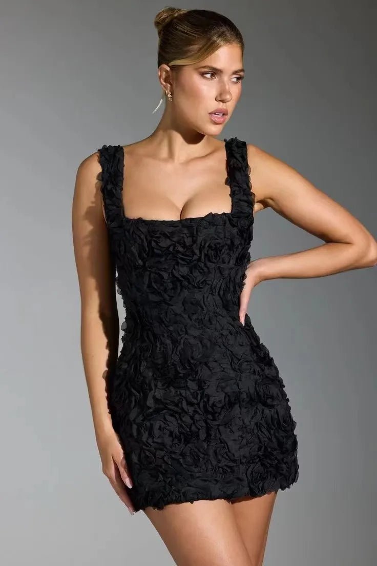 Woman wearing a black lace dress against a gray background