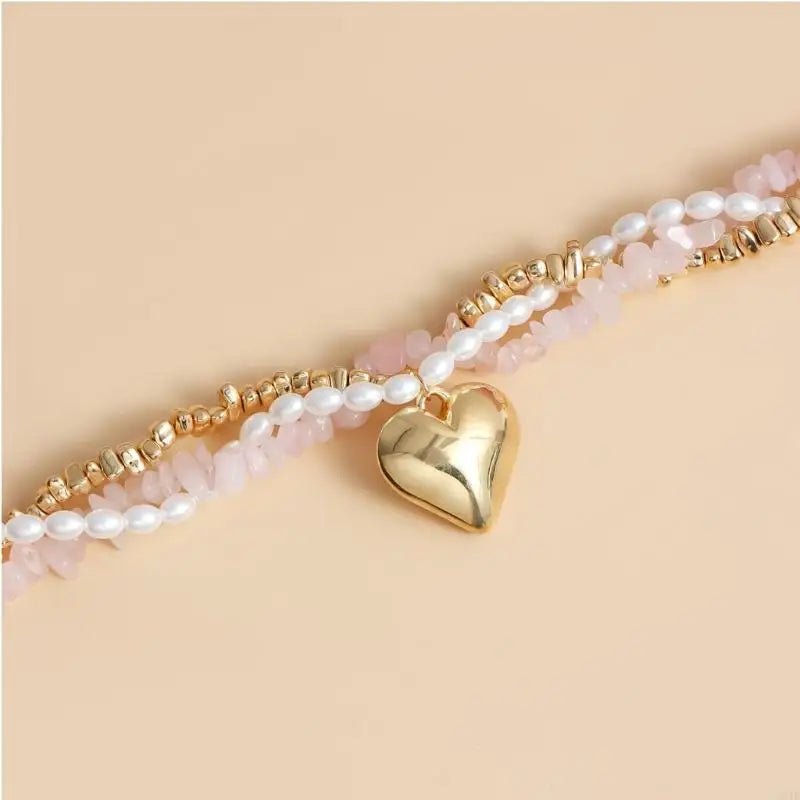 Bracelet with pearl beads and gold heart charm on a beige background