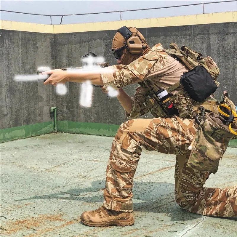 Person in camouflage military gear aiming a weapon outdoors.