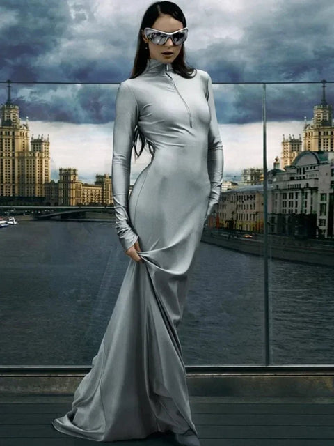 Woman in a futuristic outfit with sunglasses standing in front of a cityscape.