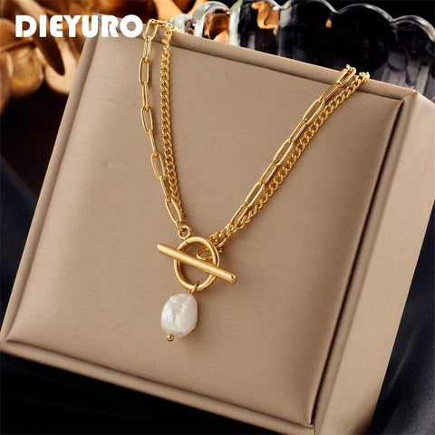 Gold necklace with a pearl pendant on a beige box, brand 'DIEYURO' visible