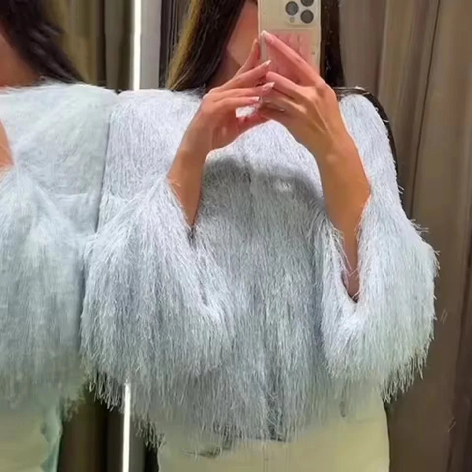 Person wearing a light blue fluffy cardigan taking a mirror selfie.