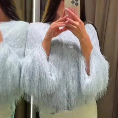 Person wearing a light blue fluffy cardigan taking a mirror selfie.