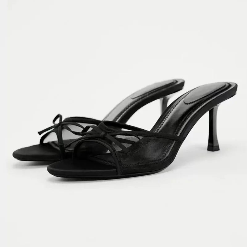 Black high-heeled sandals on a white background