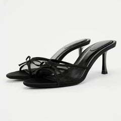 Black high-heeled sandals on a white background