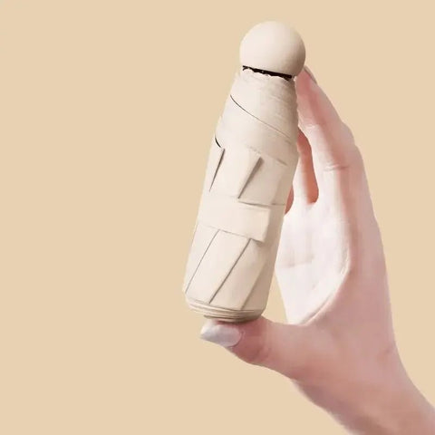 Hand holding a beige ceramic bottle against a beige background