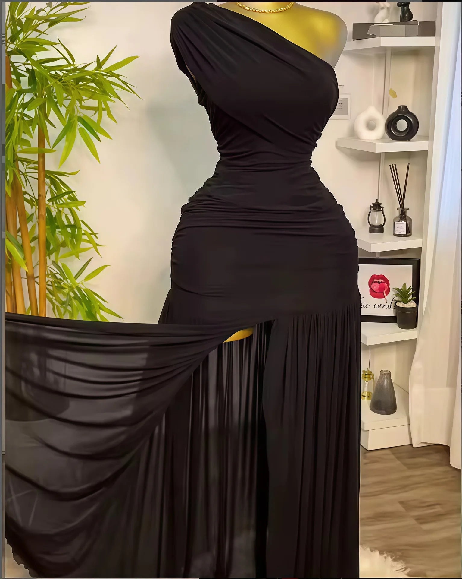 Black one-shoulder dress on a mannequin against a home interior background