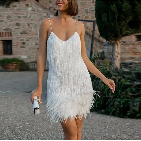 Woman wearing a white fringe dress in an outdoor setting.