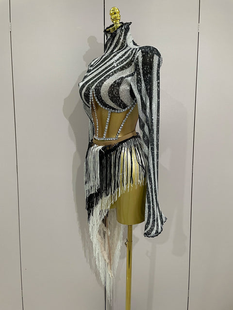 Black and white striped outfit with fringe on a mannequin against a plain background