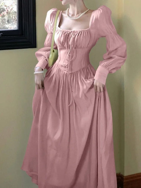 Mannequin wearing a pink historical dress against a plain background