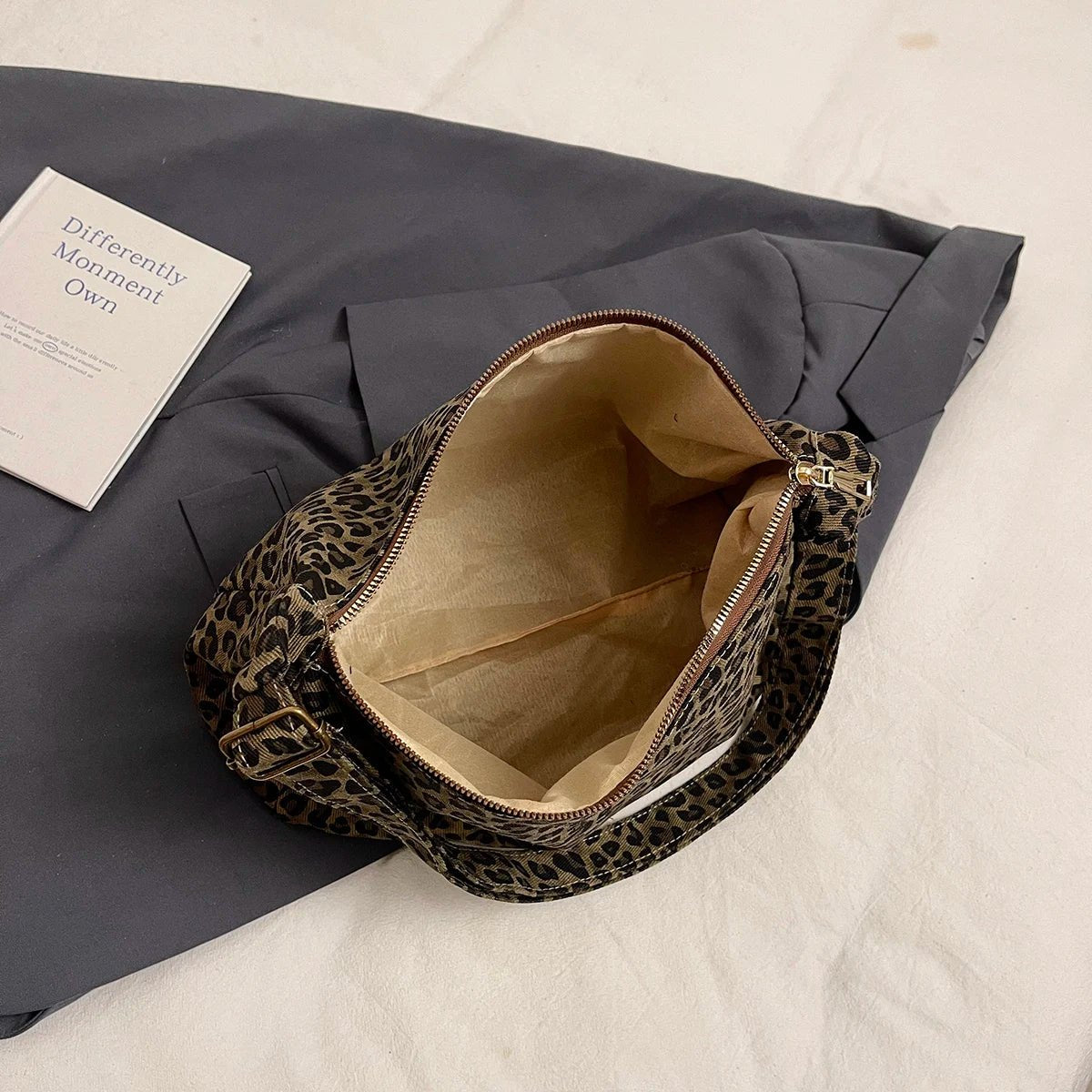 Leopard print bag with beige interior on a gray surface