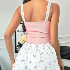 Person wearing a pink top and floral skirt with lace straps.