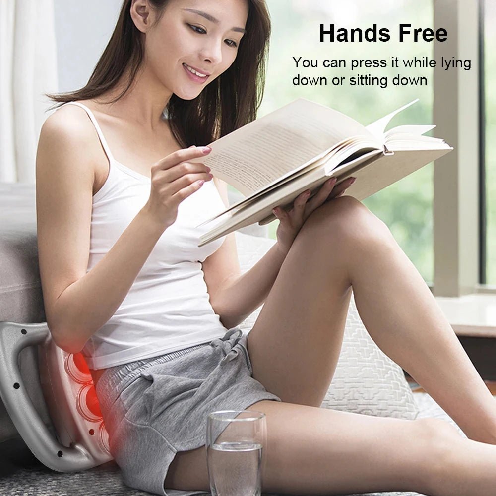 Woman reading a book with a hands-free device on her lap, sitting on a couch.