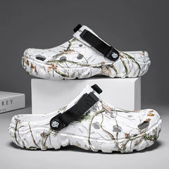 White clogs with camouflage pattern and black straps on a gray background