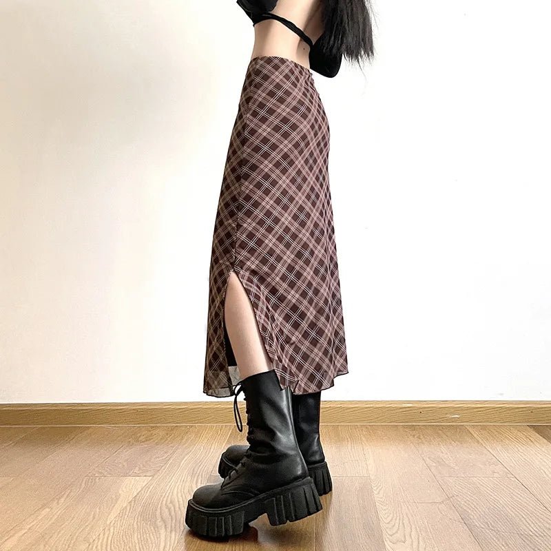 Person wearing a plaid skirt and black platform boots in a room with wooden flooring.