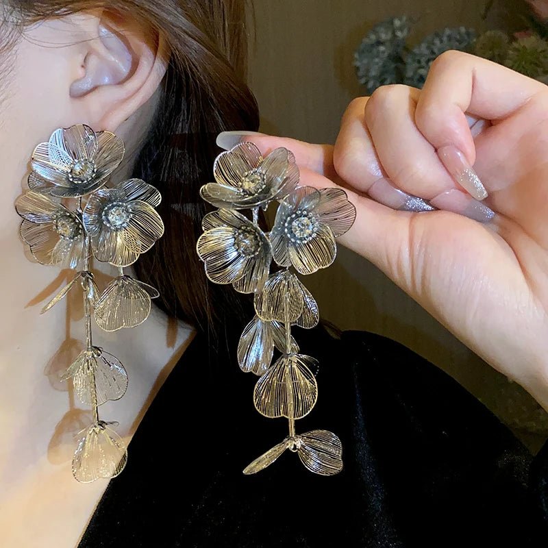 Close-up of a person wearing floral earrings with a blurred background