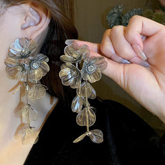 Close-up of a person wearing floral earrings with a blurred background