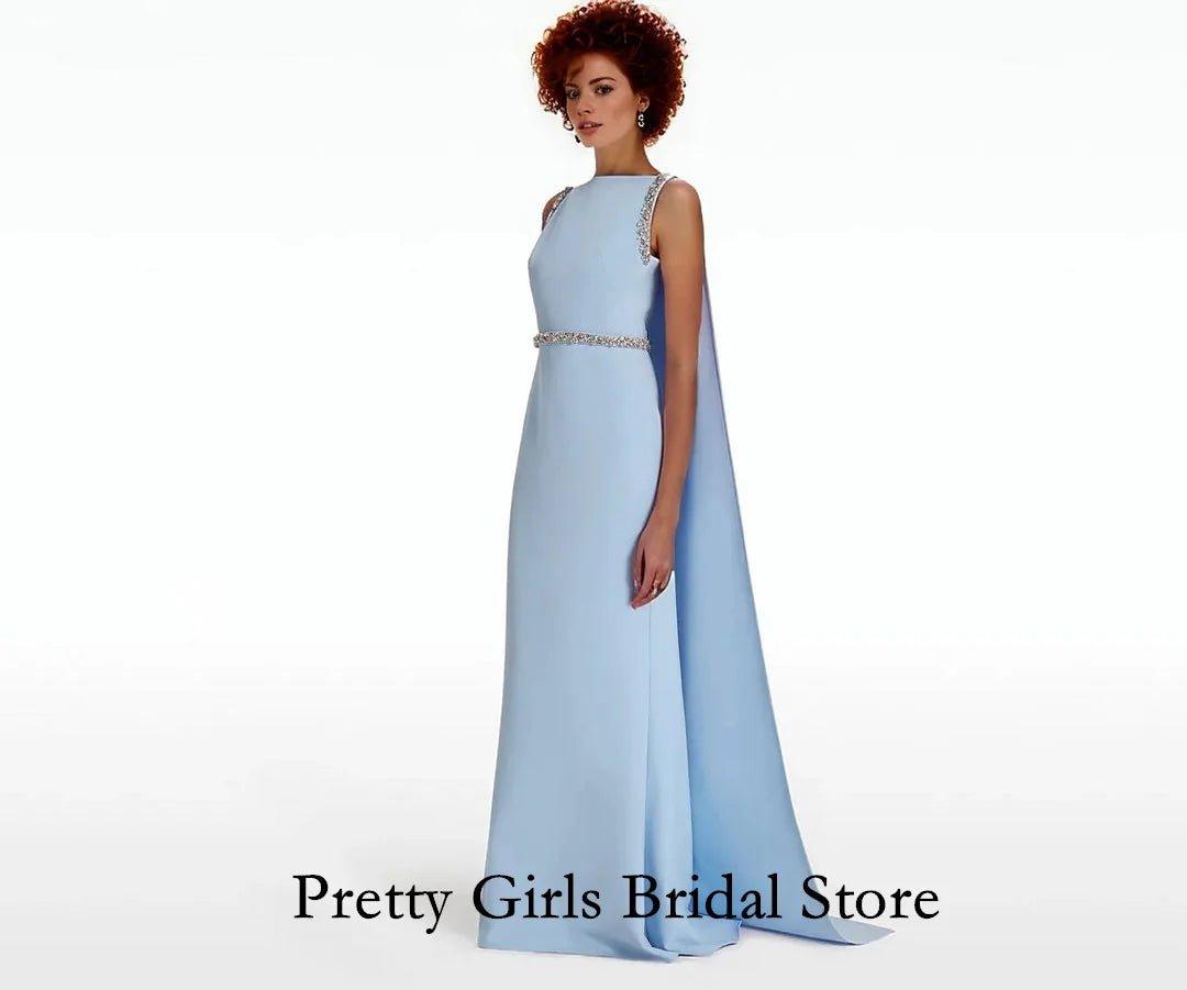 Woman wearing a light blue evening gown with a cape on a white background, branded 'Pretty Girls Bridal Store'.
