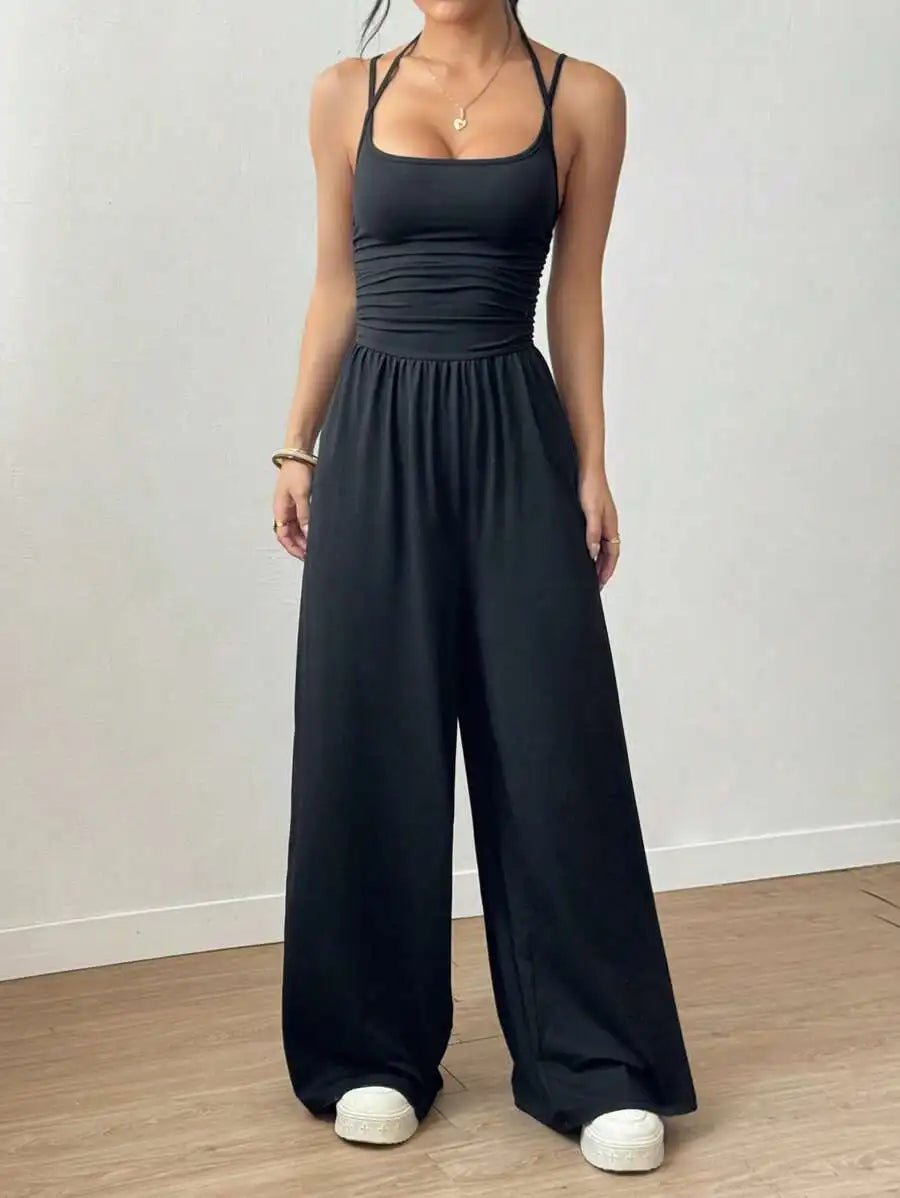 Person wearing a black jumpsuit on a plain background