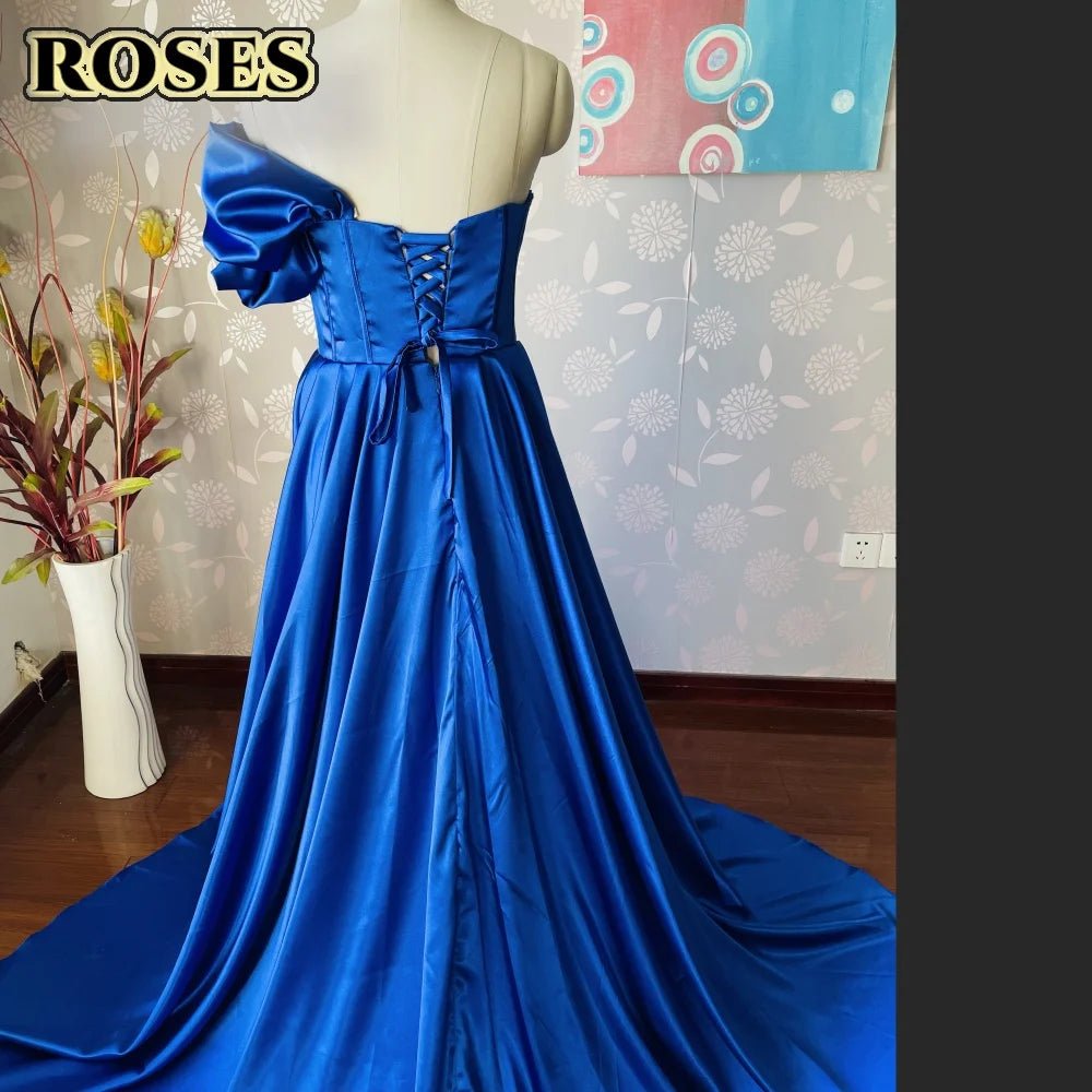 Blue evening gown on a mannequin against a floral wallpapered wall.