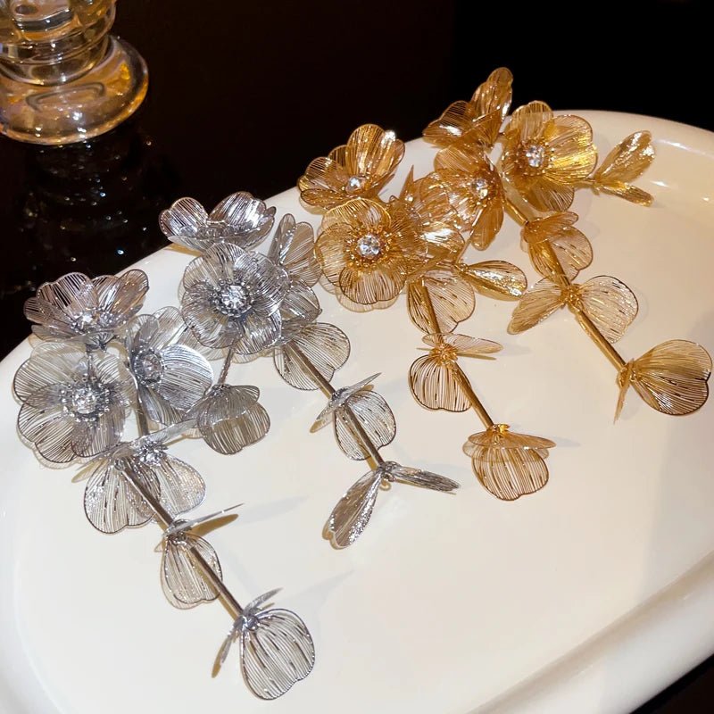 Decorative floral branches in gold and silver on a white surface.