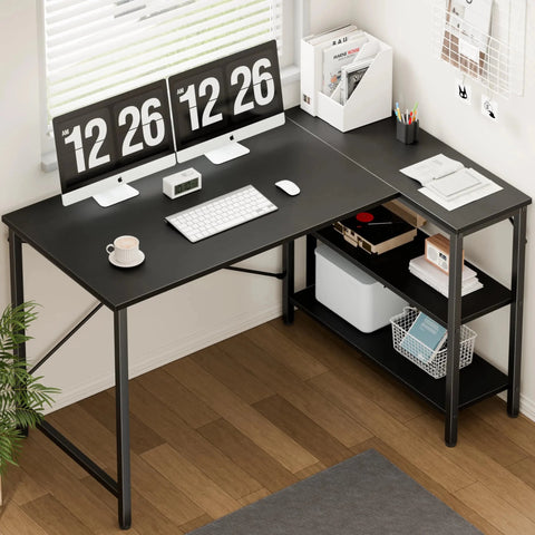 Black L-shaped desk with computer setup in a home office.