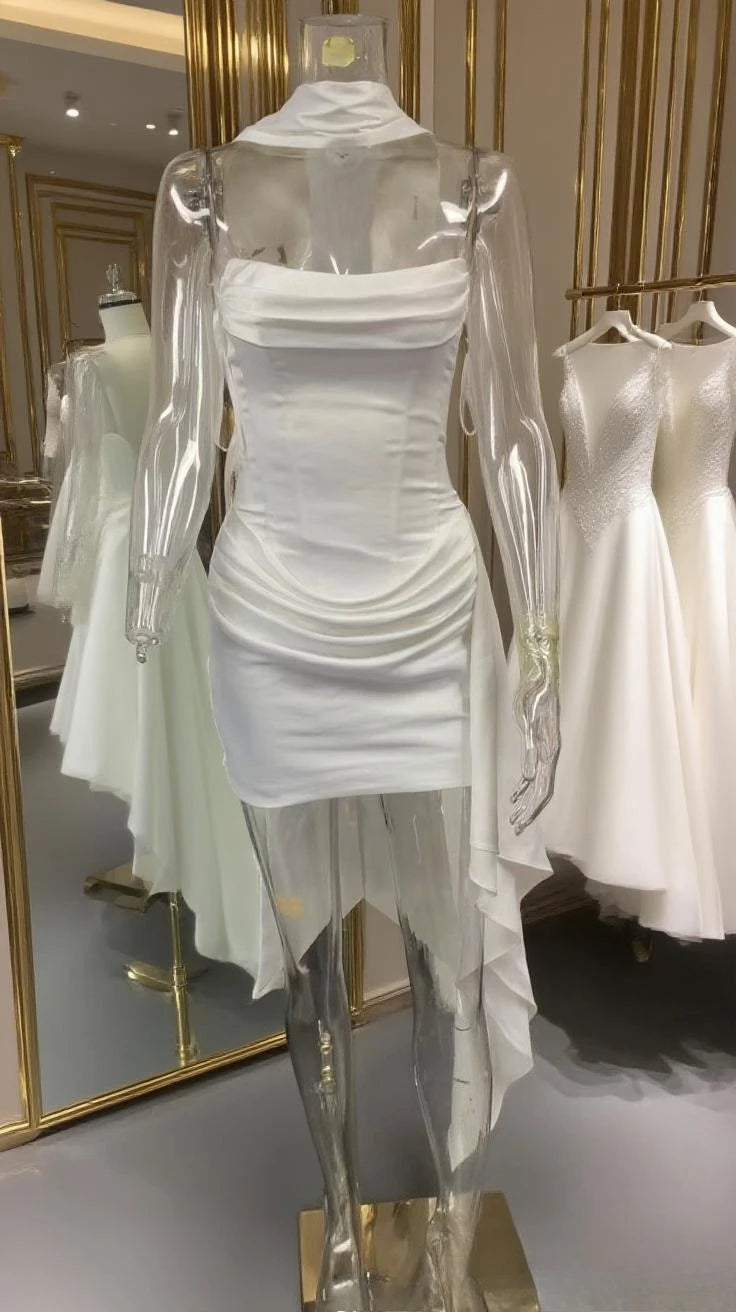 White dress on a mannequin in a store setting with mirrors reflecting other dresses.