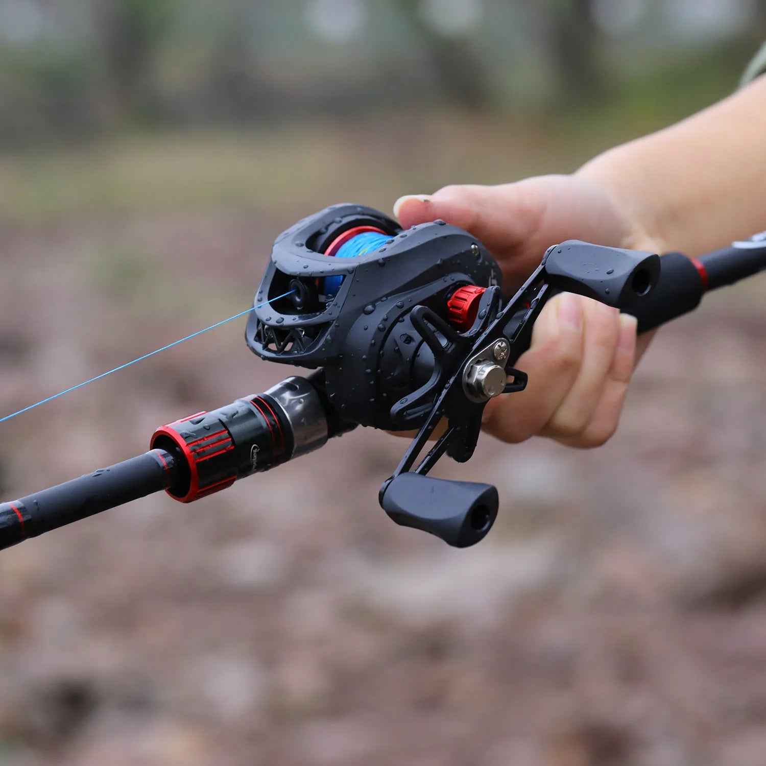 Fishing reel held by a person with a blurred natural background
