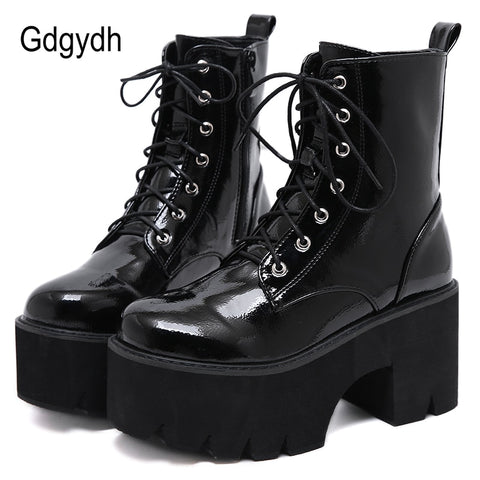 A pair of black, chunky wedge platform ankle boots with lace-up closure and a square heel.