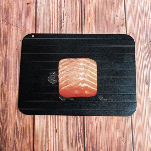 A black, rectangular defrosting tray 